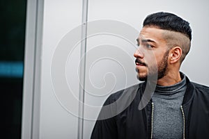 Portrait of stylish arab beard man wear grey turtleneck and black jaket. Arabian model guy against steel wall