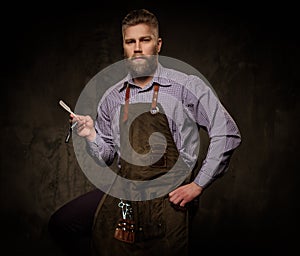 Portrait of stylish barber with beard and professional tools on a dark background.