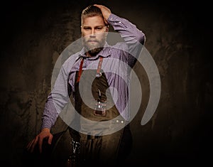 Portrait of stylish barber with beard and professional tools on a dark background.