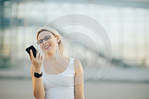 Business lady in glasses talking on the phone and smiling