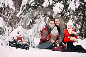 Portrait of a stylish family having a good time in the winter forest. decorated place to relax