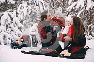 Portrait of a stylish family having a good time in the winter forest. decorated place to relax