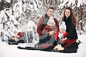 Portrait of a stylish family having a good time in the winter forest. decorated place to relax.