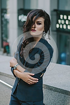 Portrait of a stylish fashionable brunette in a blue suit in the city. Fashion photo