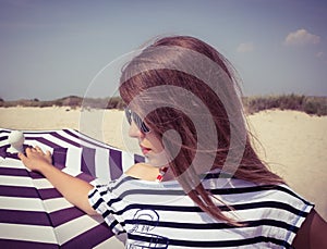 Portrait of a stylish girl in a striped t-shirt and sunglasses b