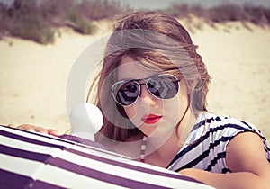 Portrait of a stylish girl in a striped t-shirt and sunglasses b