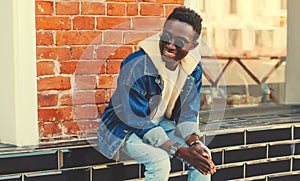 Portrait of stylish happy smiling young african man on city street