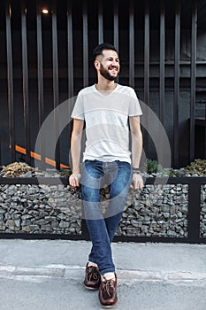 Portrait of a stylish hipster Guy, in a white empty t-shirt, sit
