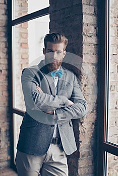 Portrait of stylish hipster minded brutal young man with bow-tie, red mustache, heavy thick beard and beautiful