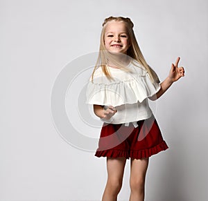 Portrait of a stylish little girl in summer clothes on a white background.