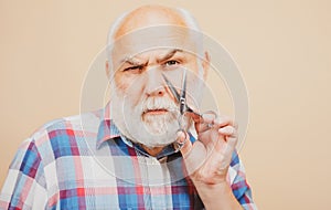 Portrait of stylish man bearded man with grey moustache beard hold barber scissors near face.