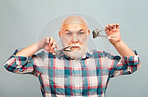 Portrait of stylish man bearded man with grey moustache beard hold scissors and straight razor hair clipper.