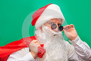 Portrait of stylish Santa Claus on color background