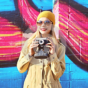 Portrait of stylish smiling girl with old retro camera