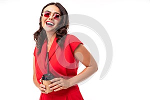 Portrait of stylish smiling girl in sunglasses and a red dress with a glass on a white background