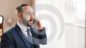 Portrait stylish smiling male businessman in suit and tie gesticulate and talking using smartphone