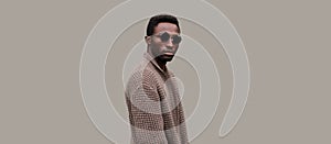 Portrait of stylish young african man model wearing knitted cardigan isolated on gray background