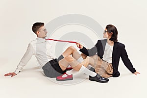 Portrait of stylish young couple, man and woman in retro suit posing  over grey studio background. Expressive