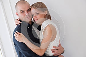 portrait of a stylish young couple stands, hugging, man looking at the camera with loving happy eyes