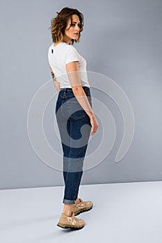 Portrait of stylish young girl in basic white t-shirt and high waisted blue jeans