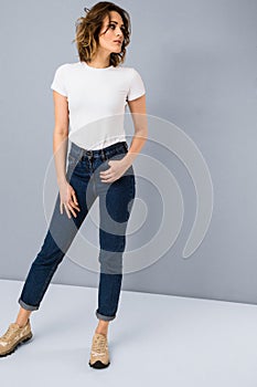 Portrait of stylish young girl in basic white t-shirt and high waisted blue jeans