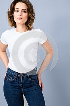 Portrait of stylish young girl in basic white t-shirt and high waisted blue jeans