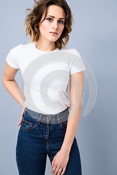 Portrait of stylish young girl in basic white t-shirt and high waisted blue jeans