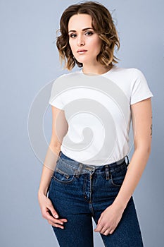 Portrait of stylish young girl in basic white t-shirt and high waisted blue jeans