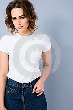 Portrait of stylish young girl in basic white t-shirt and high waisted blue jeans