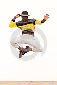 Stylish young male dancer jumping and showing his moves on white background