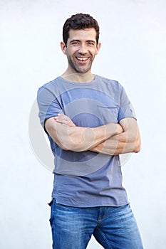 Stylish young man standing with arms crossed against white background