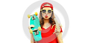 Portrait of stylish young woman blowing her lips with red lipstick holding banana and skateboard isolated on white background
