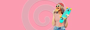 Portrait of stylish young woman with burger fast food and skateboard wearing baseball cap, sunglasses on pink background