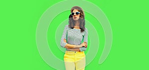 Portrait of stylish young woman model posing wearing striped t-shirt and summer straw round hat on green background, blank copy