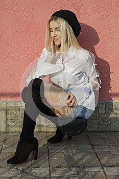 Portrait of stylish young woman in white shirt and knee high boots