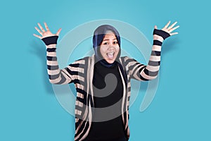 Portrait of success beautiful muslim woman wearing hijab laughing with winning victory gesture