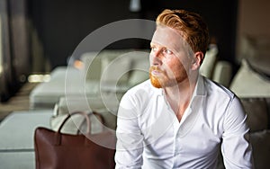 Portrait of success business man on business trip sitting in the hotel room