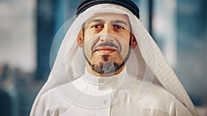 Portrait of Successful Arab Businessman in Traditional Outfit Gently Smiling, Wearing White Kandur