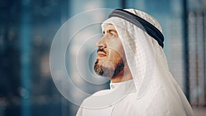 Portrait of Successful Arab Businessman in Traditional Outfit Gently Smiling, Wearing White Kandur