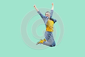 Portrait of successful beautiful short hair young stylish woman in casual striped suit jumping and celebraiting her victory,