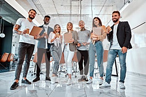 Portrait of successful business team standing together and smiling. Multi ethnic business people at startup