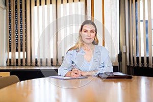 Portrait of successful business woman sitting in her office at negotiating tabl