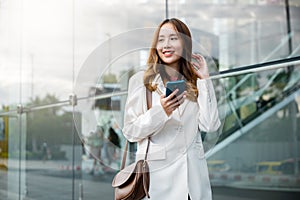 Portrait successful business woman smiling holding smartphone use application chat online in morning