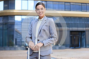 Portrait of successful business woman traveling with case at airport. Beautiful stylish female travel with luggage