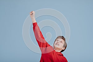 Portrait of successful child boy winner with raised hands,