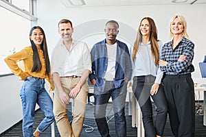 Portrait of successful diverse business people standing together at startup office.