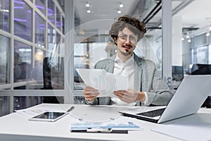 Portrait of successful financier at work at workplace inside office, mature man smiling and looking at camera