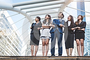 Portrait of successful group of business people looking up to sky as future. Happy businessmen and businesswomen team in