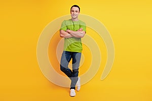 Portrait of successful guy folded arms cool posing on yellow background