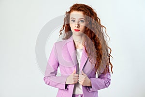 Portrait of successful happy beautiful business woman with red - brown hair and makeup in pink suit. looking at camera with smile